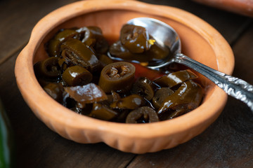 Pickled fire roasted peppers in clay dish
