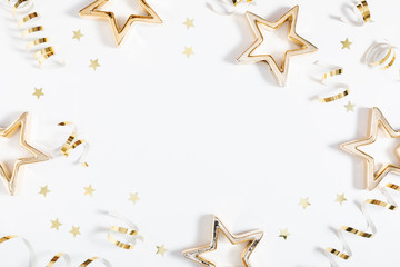 Christmas modern composition. Golden decorations, confetti, streamers, stars on white background. Christmas, New Year, winter concept. Flat lay, top view, copy space
