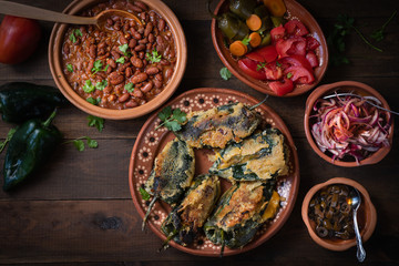Chilles rellenos served in traditional mexican dishes, served with beans, pickles