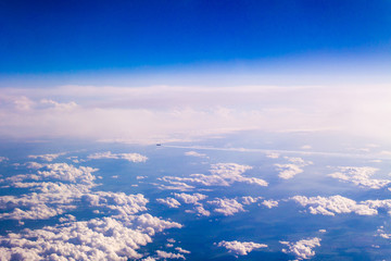 Aircraft flying away high above the clouds