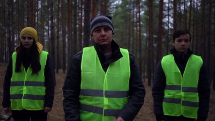 group of volunteers in green vests went in search of missing persons in a pine forest