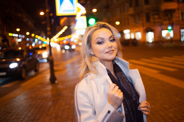 Stylish and elegant young woman in a beige coat on the city .