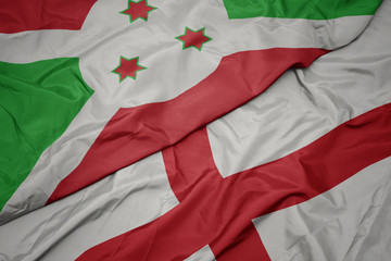 Fototapeta premium waving colorful flag of england and national flag of burundi .