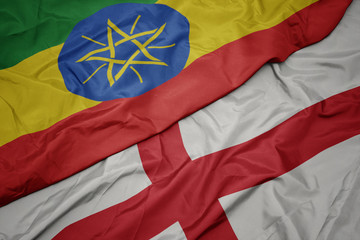 waving colorful flag of england and national flag of ethiopia .
