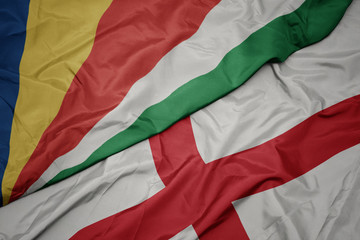 waving colorful flag of england and national flag of seychelles.