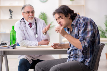 Young male alcoholic visiting old doctor