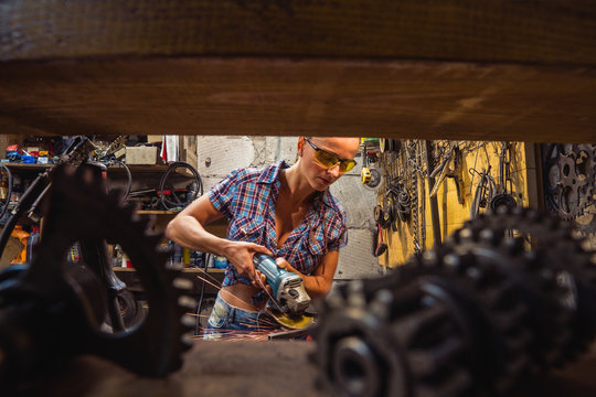 Tool grinder. A girl works with a grinder tool.