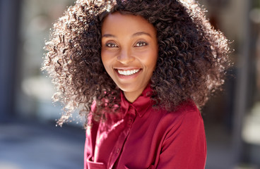 Smiling young African American woman standing on a city sidewalk