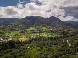 Fototapeta na wymiar Amazing panoramic view of Bella Vista valley. You can see several mountains, hills, wild vegetation and the sky full of clouds. Mindo, EcuadorPanoramic view from Mindo Valley, Ecuador.