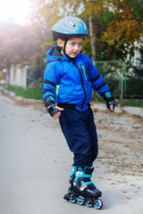 Cute little boy in a helmet on rollers