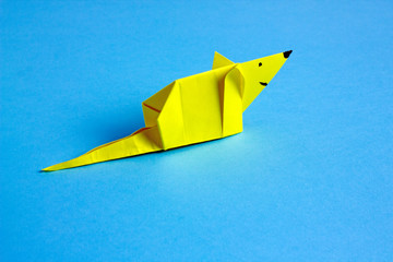  Origami paper rat yellow on a blue background. Symbol of 2020 new year. Save space