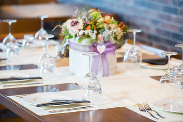 Luxury elegant table setting for dinner at a restaurant with flowers