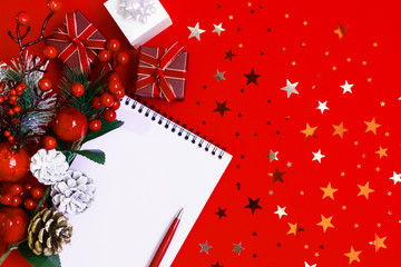 2020 new year xmas goal, plan, action text on notepad with pen, star confetti, red, black gift boxes, christmas decor on red backdrop. Motivation, inspiration concept idea, design flat lay, copy space
