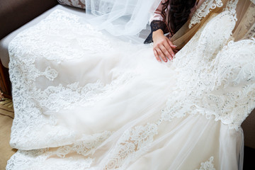 the bride holds in her hands a beautiful wedding dress