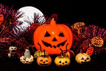 Halloween still life with pumpkin lights and devil