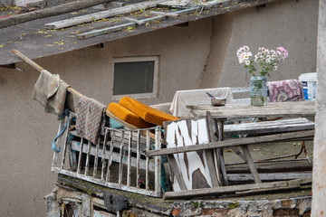 Balcony in a slum with flowers in a plastic bottle