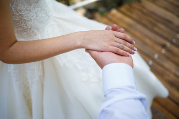 gold wedding rings in the hands of the newlyweds