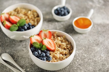Oatmeal porridge with organic blueberries, strawberries, honey and mint.