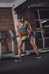 Obraz na płótnie Canvas Strong girl in the gym with medicine ball