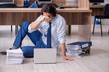 Young male employee and too many work in the office