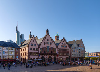 Outdoor sunny view of old town at Römerplatz, historical market square, surrounded with Römerberg, timber medieval German house, and city hall in Frankfurt, Germany.