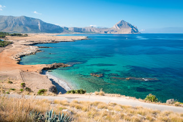 Azure Tyrrhenian sea picturesque bay, Monte Cofano mount and Bue Marino Beach view, Macari, San Vito Lo Capo region, Sicily, Italy. People are unrecognizable.
