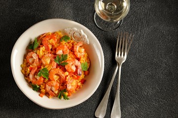 Paella or risotto with shrimp tails, carrots, onions, bell peppers, white wine and chicken stock. 