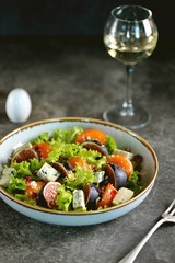 Healthy salad of persimmons, figs, blue cheese, pomegranate seeds, parmesan, lettuce and olive oil.