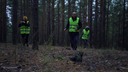 group of volunteers in green vests went in search of missing persons in a pine forest