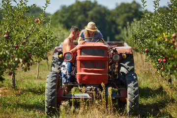 Farmers couple driving tractor