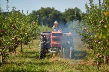 Young farmer woman driving her old tractor