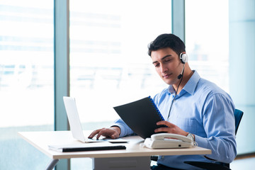 Male call-center operator in business concept