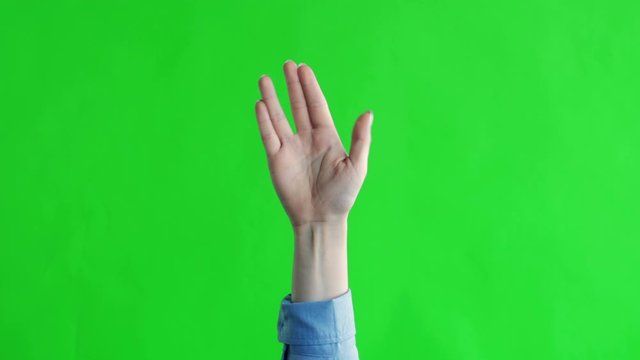 Female hand Vulcan greeting on green screen