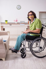 Young male student in wheelchair at home