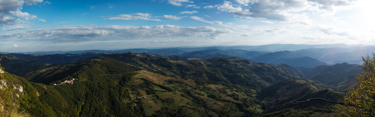 Fototapeta premium Grass hills covered with trees in steppe under spectacular clouds sky during sunset