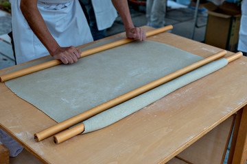 Soba making, rolling out the dough with palm and rolling poles