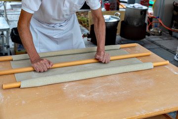 Soba making, rolling out the dough with palm and rolling poles