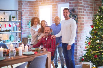 Beautiful family smiling happy and confident. Standing and posing with tree celebrating Christmas at home