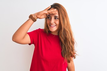 Young redhead woman wearing red casual t-shirt stading over white isolated background very happy...