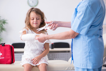 Little girl visiting old female doctor