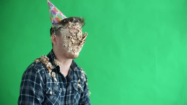 Throw birthday cake at mans face, he smiles and laughs in slow motion