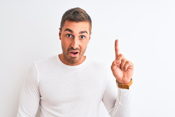 Fototapeta premium Young handsome man wearing white shirt over isolated background pointing finger up with successful idea. Exited and happy. Number one.