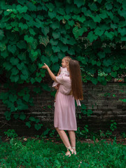 Mom and daughter walk and play in the park. Dressed in dresses. Sunny day, weekend in a city park.