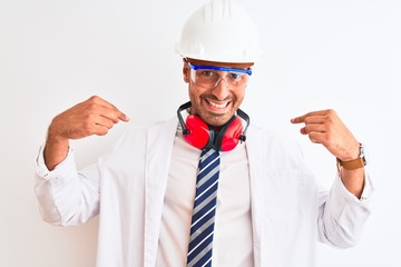 Young chemist man wearing security helmet and headphones over isolated background looking confident with smile on face, pointing oneself with fingers proud and happy.