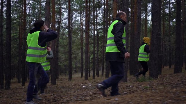 group of volunteers in green vests went in search of missing persons in a pine forest