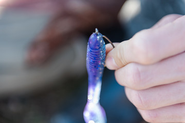 Fisherman puts on silicone bait. Jig fishing. Silicone gear. Tackle for fishing.