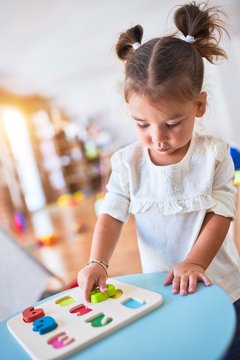 Young beautiful toddler learning mathematics playing with maths game at kindergaten