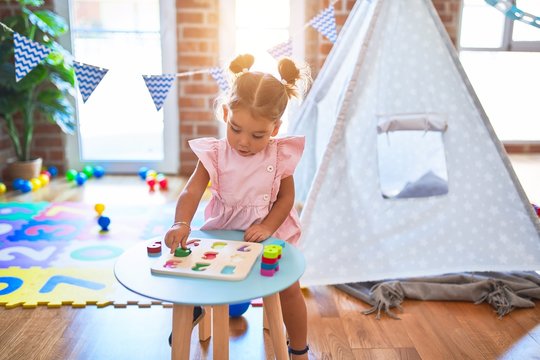 Young beautiful toddler learning mathematics playing with maths game at kindergaten