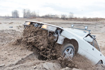 Rally on the sand. Broken car rides on the sand. Off-road driving. The car jumps on a springboard.