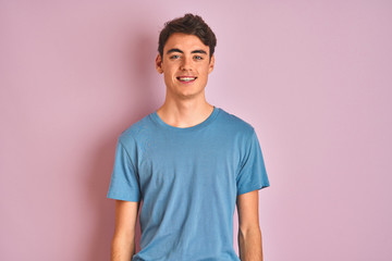 Teenager boy wearing casual t-shirt standing over blue isolated background with a happy and cool...